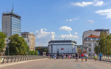 Nis, Serbia - August 04, 2022: People Walking at Wide Pedestrian Bridge Over Nisava River and King Milan Square in City Centre Hot Summer Day.
