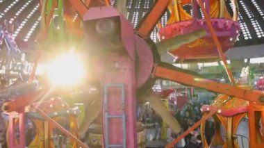 Belgrade, Serbia - December 25, 2022: Kids Ferris Wheel Sun Rays Winter Fairground in Hall Amusement Park Family Ride.