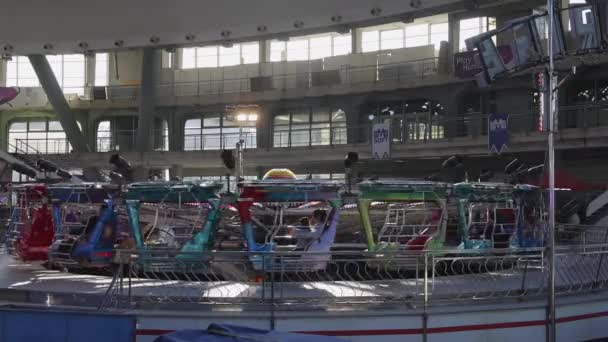 セルビア ベオグラード 2022年12月25日 安全ケージアミューズメントパークに乗ってゴンドラを回転させる大規模な展示ホールで冬の楽しみフェア — ストック動画