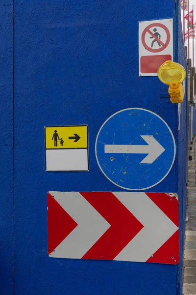 Pedestrians Way Arrow Sign With Beacon Warning Light at Construction Site Fence