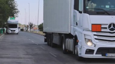 Horgos Roszke, Hungary - August 01, 2022: White Cargo Truck Shipping Logistics and Long Queue of Trucks Stuck at EU Border Entry pan.