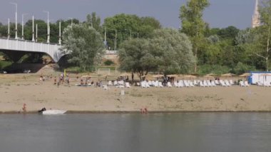 Szeged, Hungary - August 01, 2022: People Relax at Sandy Beach Tisza River Coast Hot Sunny Summer Day Panorama.