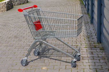 One Empty Shopping Cart at Pavement in Front of Store