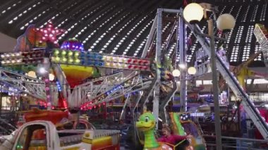 Belgrade, Serbia - December 25, 2022: Helicopters Aircrafts Cabins Spinning Carousel Twister for Kids Ride Amusement Park in Hall.