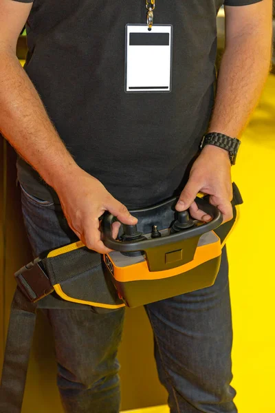 Worker Holding Remote Control With Joysticks for Construction Machinery