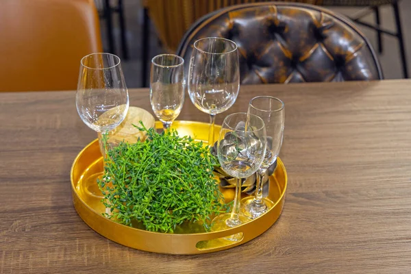 ダイニングテーブルでラウンドゴールドトレイに空のワイングラス — ストック写真