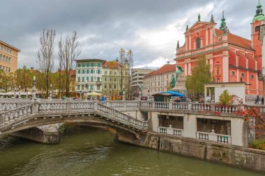 Ljubljana, Slovenya - 4 Kasım 2019: Başkent Bulutlu Sonbahar Günü 'nde Ljubljanica Nehri üzerindeki üçlü köprü.
