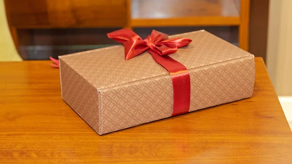 Geschenkverpackung Mit Roter Schleife Holztisch — Stockfoto