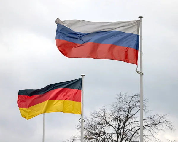 Russian Federation and Germany Flags Together at Cloudy Sky