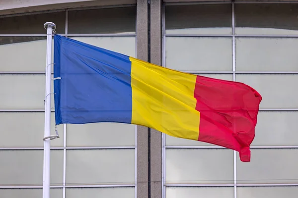 stock image National Flag of Romania Country in Front of Glass Building