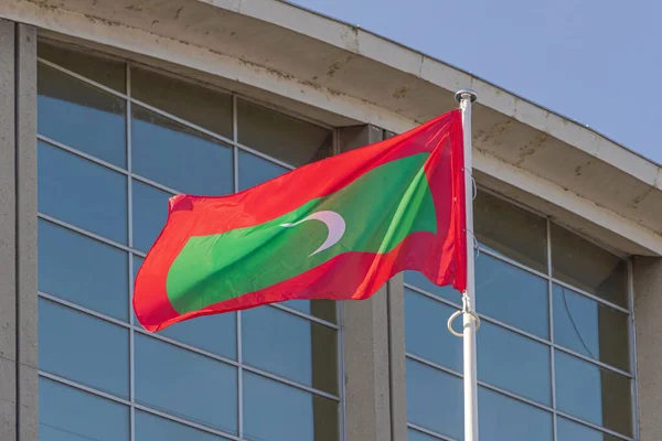 Σημαία Δημοκρατίας Των Μαλδίβων Μπροστά Από Γυάλινο Κτίριο — Φωτογραφία Αρχείου