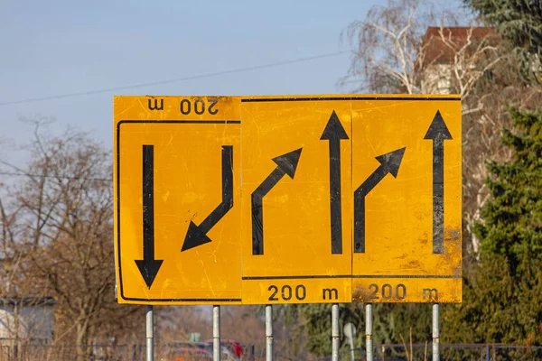 黄色の背景でサイドダウン矢印混沌とした交通標識 — ストック写真