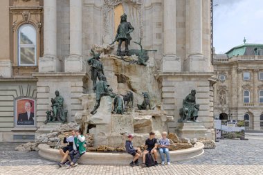 Budapeşte, Macaristan - 31 Temmuz 2022: Bronz Heykellerin önünde oturan Turistler Kral Matthias 'ın Av Motivasyonu Çeşmesi Birinci İlçe Tarihi Tarihi Kalesi.