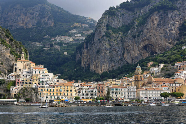 Amalfi, Italy - June 28, 2014: Picturesque Small Town and Big Cliffs and Hills Summer Day at Amalfi Coast Travel.