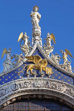 Venedik, İtalya - 19 Aralık 2012: Altın Aslan ve Mermer Heykel Sunny Day 'de St. Marks Bazilika Batı Cephesi' nin en tepesinde.