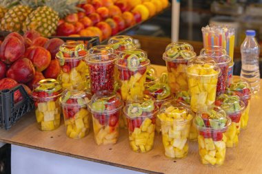 Plastik bardaklardaki taze meyveler yemeye hazır.