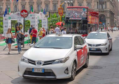 Milan, İtalya - 15 Haziran 2019: Beyaz Melez ve Elektrik Taksi Araçları Yaz Günü Şehir Merkezi 'nde Sokak' ta.