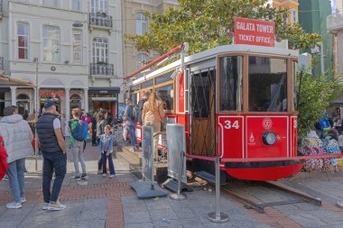 İstanbul, Türkiye - 19 Ekim 2023: Galata Kulesi önündeki Turistler Tarihi Kırmızı Tramvay Beyoğlu Bilet Ofisi.