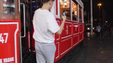 İstanbul, Türkiye - 17 Ekim 2023: Istiklal Caddesi 'ndeki Kalabalık ve Eski Kentteki Taxim Meydanı Gecesinde Polis Mirası Tramvayı.