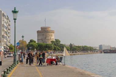 Selanik, Yunanistan - 22 Ekim 2023: İnsanlar Sonbahar Pazar günü Beyaz Kule 'nin Önündeki Promendae' de Yürüyor.