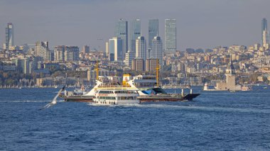 İstanbul, Türkiye - 19 Ekim 2023: Feribot gemisi Boğaz Kanalı 'nda ve Gökdelenler Ofisi Modern Şehir Gökdeleni Günes Günü' nde.