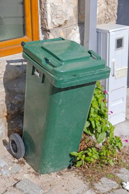 Yeşil Plastik Tekerlek Kutusu Cobbled Caddesi 'nde.