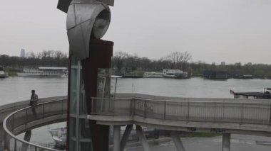 Belgrad, Sırbistan - 11 Mart 2024: Sava Nehri 'ndeki Yüzen Restoranlar ve Pedestrian Üstgeçit Köprüsü Yağmurlu Hava Panoraması.