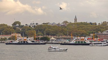 İstanbul, Türkiye - 18 Ekim 2023: Tepedeki Topkapı Sarayı ve Eski Şehirdeki Feribot Bulutlu Sonbahar Günü.