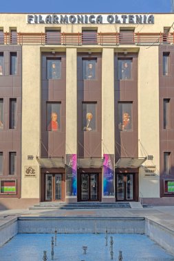 Craiova, Romanya - 16 Mart 2024: Calea Unirii Street Sunny Day 'deki Filarmoni Orkestrası Oltenia Konser Salonu Binası Önündeki Boş Çeşme.