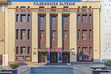 Craiova, Romanya - 16 Mart 2024: Calea Unirii Caddesi Sunny Spring Day 'deki Filarmoni Orkestrası Oltenia Konser Salonu Binası Girişi.