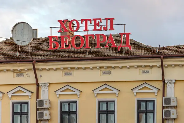 stock image Negotin, Serbia - March 14, 2024: Red Letters Cyrillic Sign Hotel Beograd at Top of Old Building Spring Afternoon.