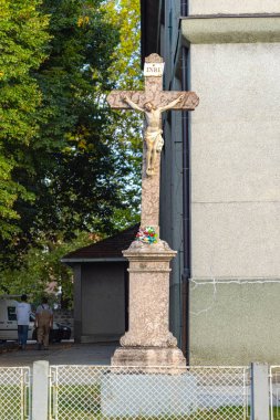 Temerin, Serbia - September 18, 2021: Marble Cross Crucifixion in Front of Church of Saint Rosalia. clipart