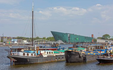 Amsterdam, Hollanda - 16 Mayıs 2018: Kentteki Su Kanalı ve Nemo Müzesi Binası 'na demirli mavnalar.