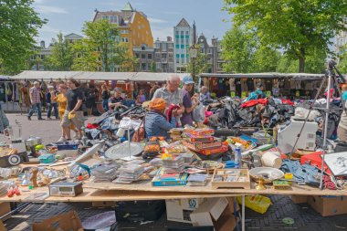 Amsterdam, Hollanda - 16 Mayıs 2018: Büyük İkinci El Giysi Yığını ve Kullanılmış Knick Knacks İnsanlar Güzel Bahar Günü 'nde Bit Pazarı' ndan alışveriş yapıyor.