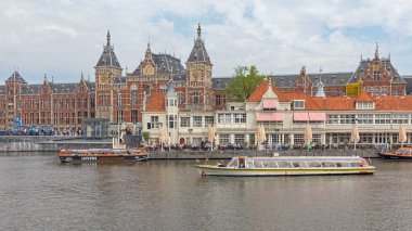 Amsterdam, Hollanda - 16 Mayıs 2018: İlkbahar Günü Şehir Merkezi 'ndeki Ana Tren İstasyonu Binası önünde Aşıklar Seyahatleri ve Kanal Tekneleri.