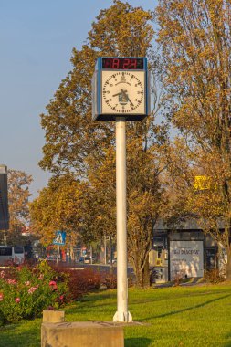 Slavonski Brod, Hırvatistan - 22 Ekim 2024: Sunny Morning Sonbahar sabahı otobüs durağının önündeki Dijital Tarihli Analog Kamu Saati.