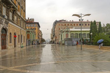 Rijeka, Croatia - October 24, 2024: Few People With Umbrellas at Wet Street Verdijeva Rainy Autumn Day in City. clipart