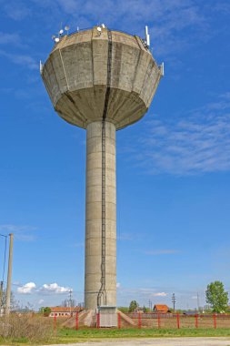 Tall Concrete Tower Water Supply for Village With Wireless Antennas Blue Sky Spring Day clipart