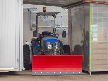 Örtüsü Altında Kırmızı Kar Tarlası olan Küçük Traktör Kışa Hazır