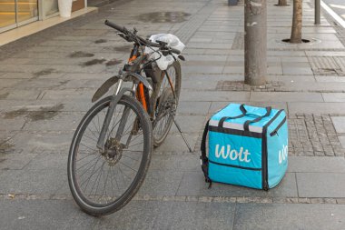 Belgrad, Sırbistan - 04 Mayıs 2024: Elektrik Bisikleti ve Wolt Fast Food Delivery Company Street Pavement 'te İzolasyon Kutusu.