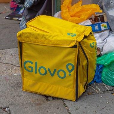 Belgrad, Sırbistan - Mayıs 04, 2024: Fast Food Company Glovo için Sarı Teslimat Kutusu.
