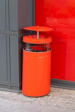 Tepesinde kaplanmış kül tablası olan Modern Kırmızı Çöp Kutusu