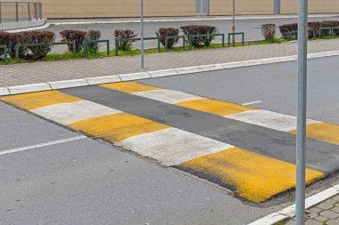 Şehir Caddesinde asfalttan yapılmış sarı ve beyaz hız tümseği