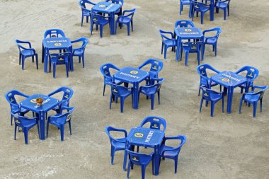 Florence, İtalya - 30 Eylül 2009: Ünlü Avustralyalı Bira Fosterları Arno Nehri Sahilinde Mavi Plastik Masa ve Sandalyeler.