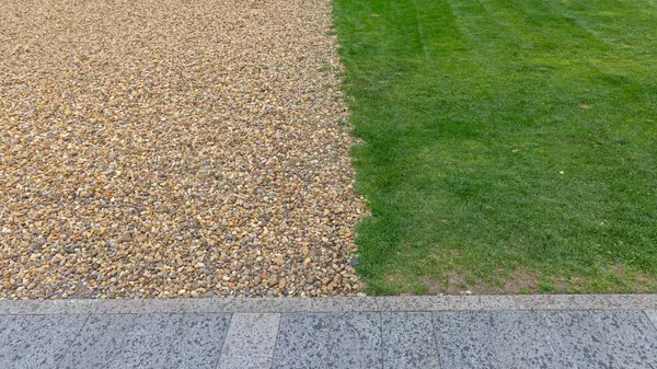 Şehir parkında çakıl ve yeşil çim ayırma hattı.