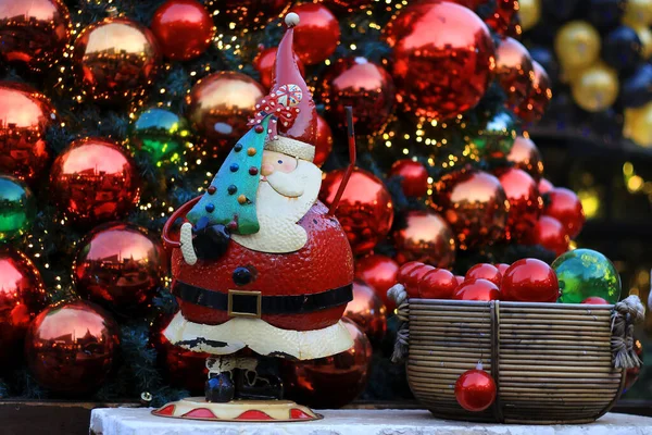 Een Kerstman Die Een Kerstboom Tegen Een Kerstballen Achtergrond Houdt — Stockfoto