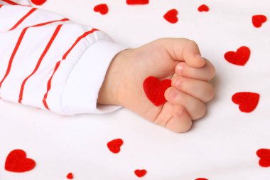 Kırmızı bir keçeli bebek bir el.