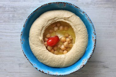 Bol zeytinyağı, nohut ve vişneli domatesli geleneksel Lübnan humus tabağı..