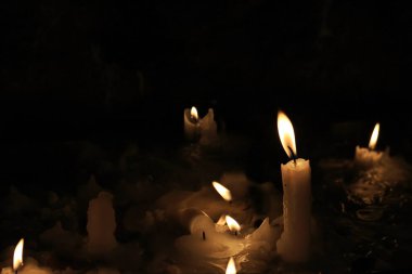 Bir kilisede mumlar yanıp sönüyor ve eriyor..