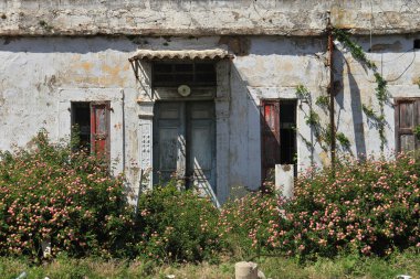 Lübnan 'ın kıyı kenti Jbeil' de pencereleri ve kapısı yıpranmış bir ev cephesi.